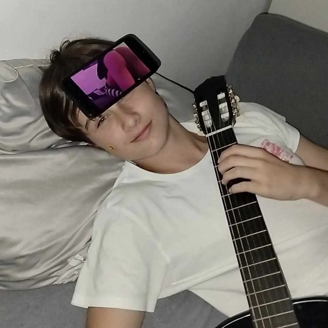 a picture of me with laying in bed with i think a guitar and some stickers are on me